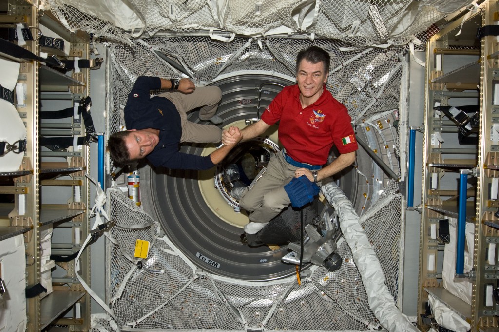 On 23 May 2011, ESA astronauts Paolo Nespoli (left) and Roberto Vittori shake hands inside the ATV following an Earth-to-space phone tag-up with Italian President Giorgio Napolitano. Credit: NASA