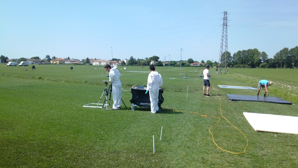 The group from Milan spraying plots. The plot as the back is visible with the white inert kaolin powder. On the right, the team from Luxembourg is preparing several calibration targets with known albedo. (ESA)