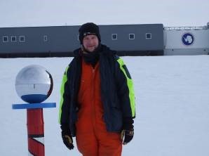 Tom Jordan at the South Pole, with the station in the background. (BAS)