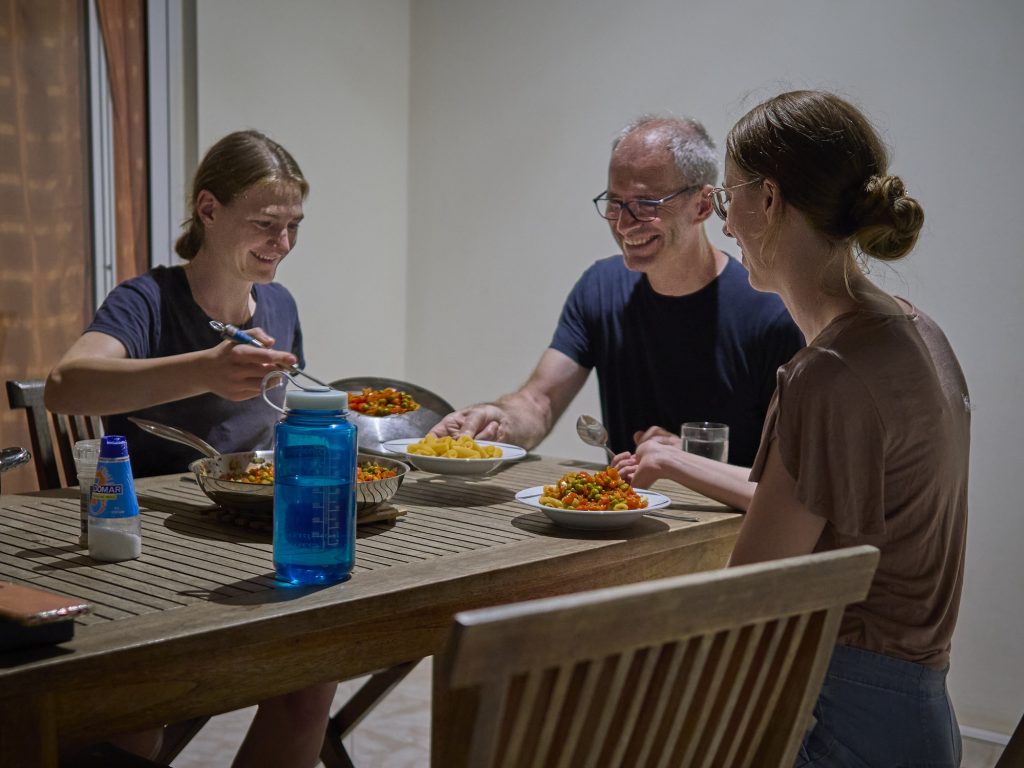 Lea, Bernhard, and Veronika sit down for a well-earned, home-cooked dinner after a hard day’s work. (Meteorological Institute Munich, LMU-Bernhard Mayer)