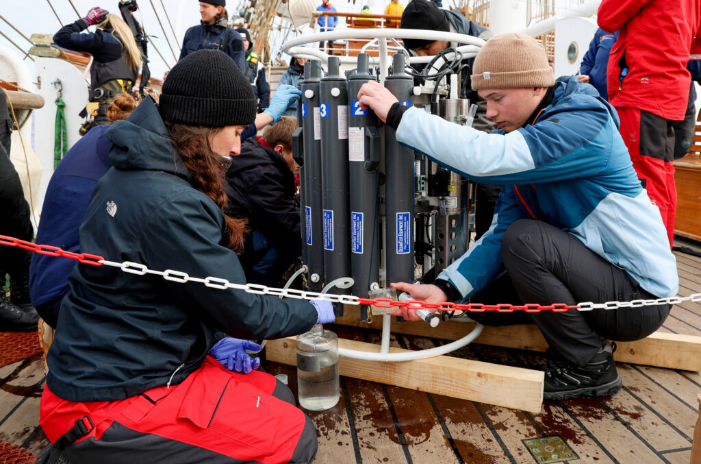 The biology team & students collecting water from the conductivity, temperature and depth rosette. (Ocean Media Lab)