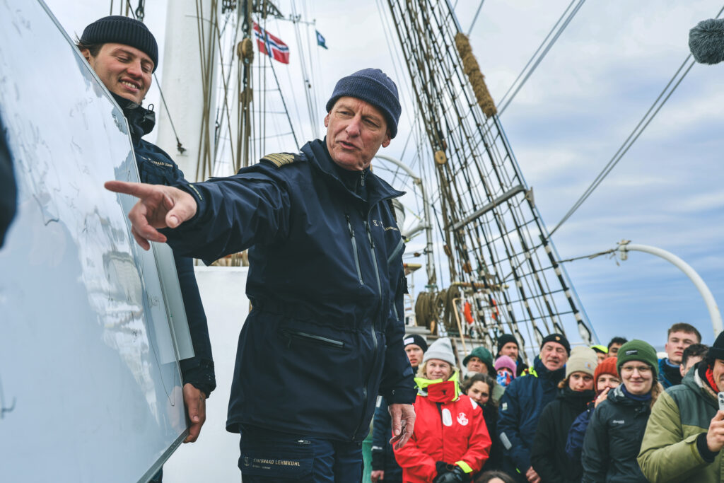 Captain Marcus Seidl gives briefing about the weather, and deciding whether to take the north or south route around Iceland. (Ocean Media Lab)