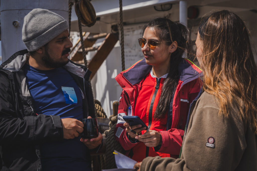 Between deployments, students discuss chlorophyll concentration patterns observed in Sentinel-3 data and how they align with the physical measurements collected at sea. From left to right: João Vitor Langor Bueno, Sejal Pramlall & Lou Andrès. (Ocean Media Lab)
