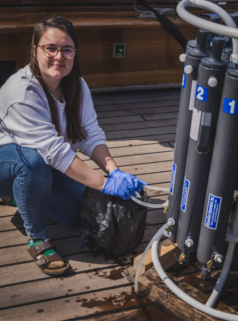 Student, Marie-Christin Juhl, collects water from the CTD bottles, readying it for nutrient and biological analysis. (Ocean Media Lab)