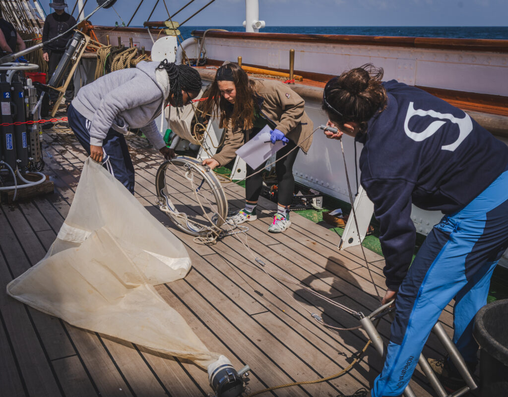 Students, Eva Chamorro, Salma Sheini & Lou Andrès coordinate the launch of a fine-mesh plankton net, another layer of biological data collection that complements satellite indicators of productivity. (Ocean Media Lab)