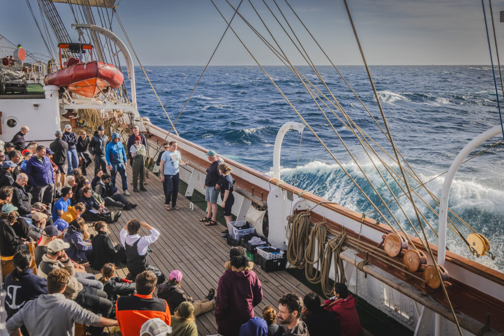 Briefing on the main deck brings everyone together. With the Atlantic rolling, students and crew work on science plans, safety, and a shared purpose. (Ocean Media Lab)