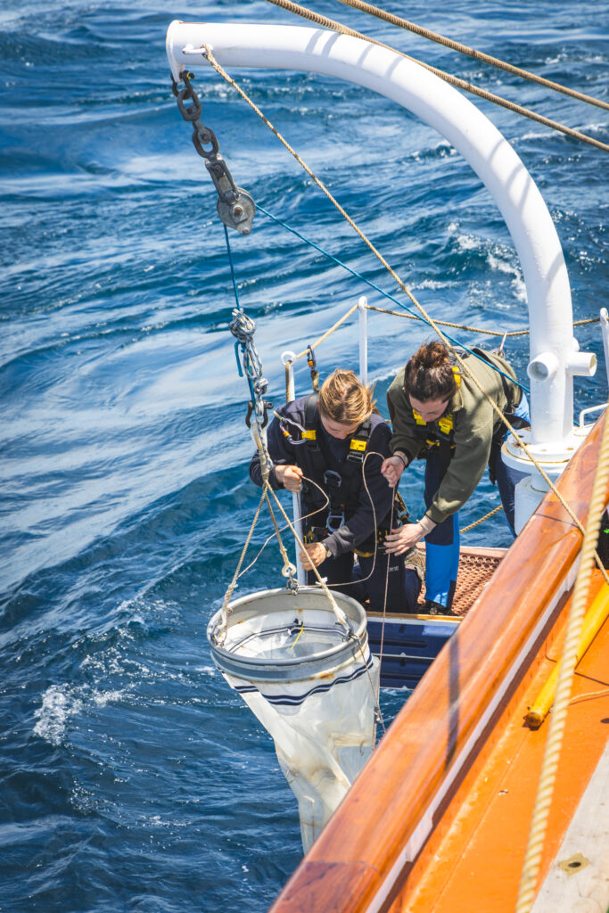 Crew Tuva Sandven and student Eva Chamorro coordinate the launch of a fine-mesh plankton net. (Ocean Media Lab)