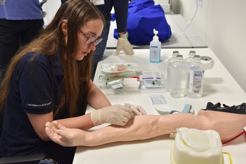 Rosemary Coogan practising blood draw on a dummy arm. Credits: ESA/DLR
