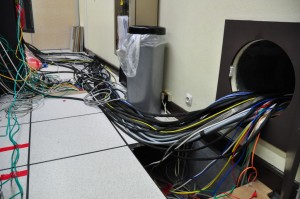 Cables run from the control room to the satellite in the clean room through a hole in the wall.