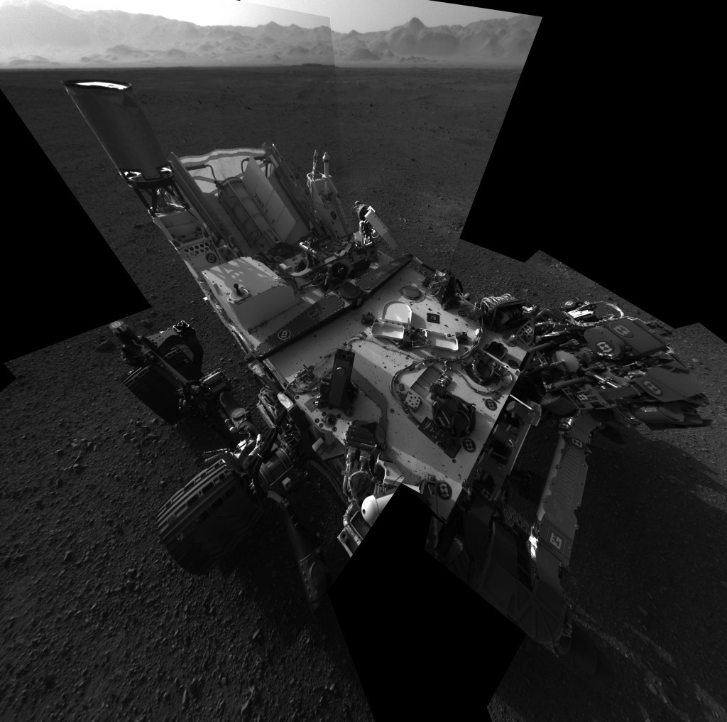 Still Life with Rover This full-resolution self-portrait shows the deck of NASA's Curiosity rover from the rover's Navigation camera. The back of the rover can be seen at the top left of the image, and two of the rover's right side wheels can be seen on the left. The undulating rim of Gale Crater forms the lighter color strip in the background. Bits of gravel, about 0.4 inches (1 centimeter) in size, are visible on the deck of the rover. Credit: NASA