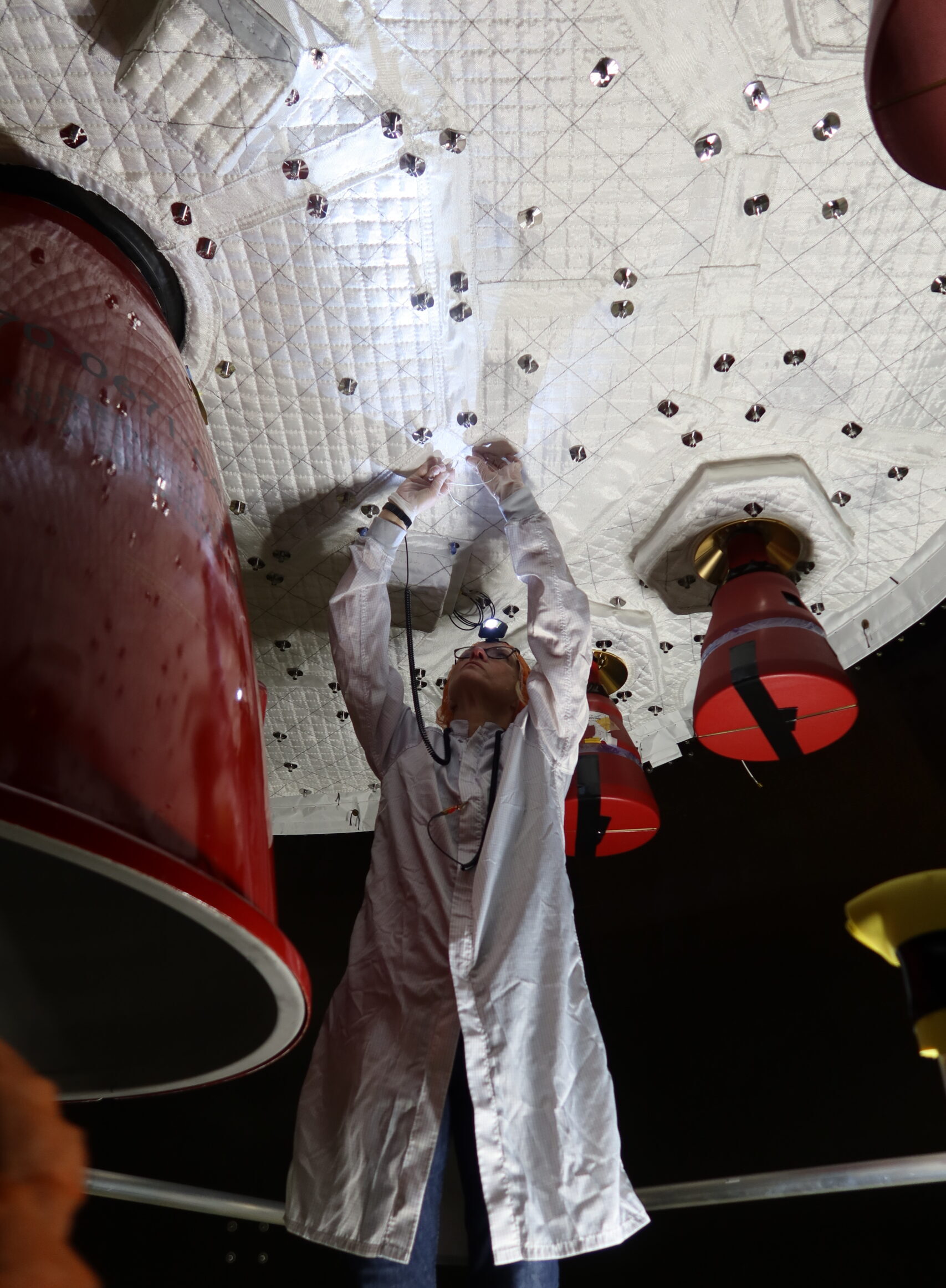 Sewing the module by hand, with the enormous main engine on the left. Credit: NASA