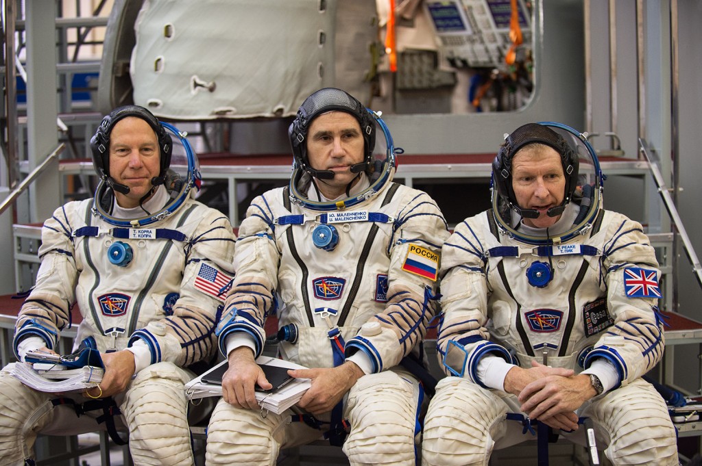 Expedition 45/46 crew Tim Kopra, Yuri Malenchenko and Tim Peake in front of Soyuz simulator. Credits: UKSA-M. Alexander
