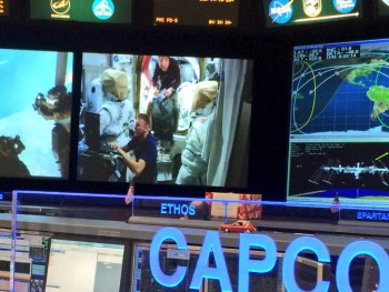 Tim Peake and Tim Kopra working on their spacesuits seen on a monitor of NASA mission control. Credits: David Saint-Jacques