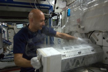 ESA astronaut Luca Parmitano using the Space Station's freezer for sample storage. Credits: ESA/NASA
